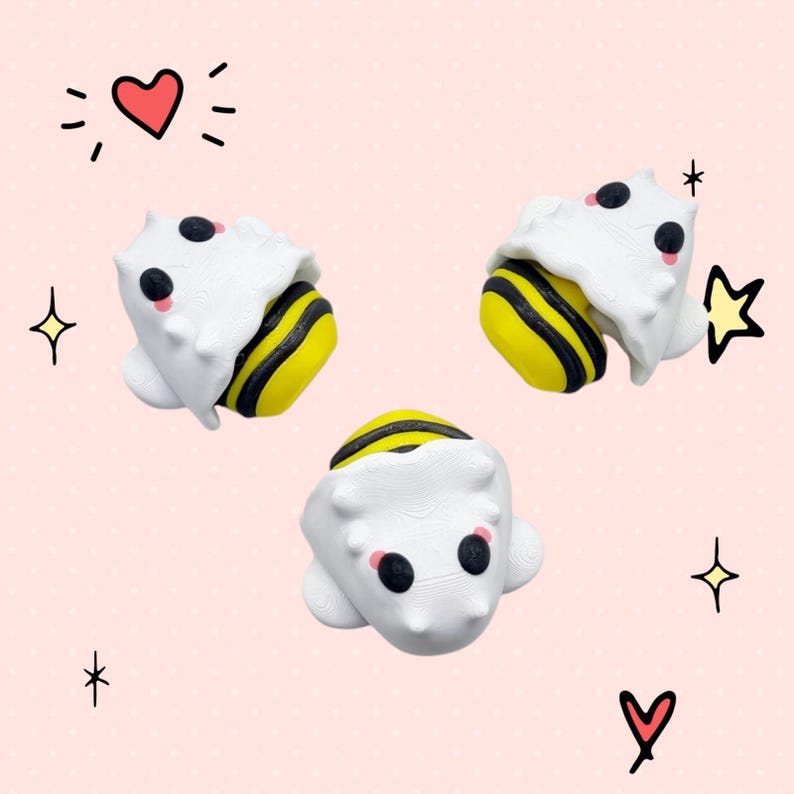 May include: Three white and yellow bee figurines with black eyes and pink cheeks. The bees are in a curled up position, as if they are sleeping.