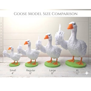 May include: A size comparison of goose models. The white geese have orange beaks and feet, and are standing on green bases. The sizes are labeled: Small (10 cm), Regular (15 cm), Large (20 cm), and XL (30 cm). The geese are gesturing with a raised middle finger.