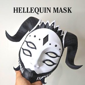 May include: A white and black Harlequin mask with curved horns and multiple eye shapes. The mask has a diamond shape on the forehead and is labeled "HELLEQUIN MASK" in black text.