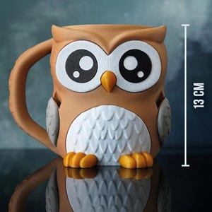 May include: A brown owl-shaped mug with large white eyes and a yellow beak. The mug has a handle and is 13 cm tall. The owl's chest is white with a textured pattern, and it has orange feet.