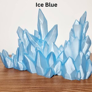 May include: A cluster of ice blue crystals, resembling a frozen mountain range, is a decorative tabletop sculpture.