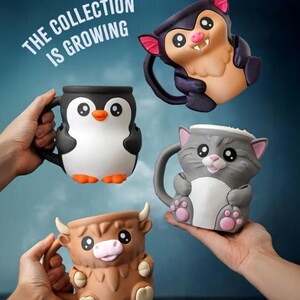 May include: Four ceramic mugs in the shape of animals are displayed. The mugs are a penguin, a bat, a cat, and a highland cow. The penguin is black and white with orange feet. The bat is purple and tan. The cat is gray and white. The cow is brown.