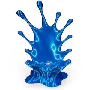 May include: A blue 3D printed phone stand shaped like a splash of liquid. The stand has a small opening for a charging cable.