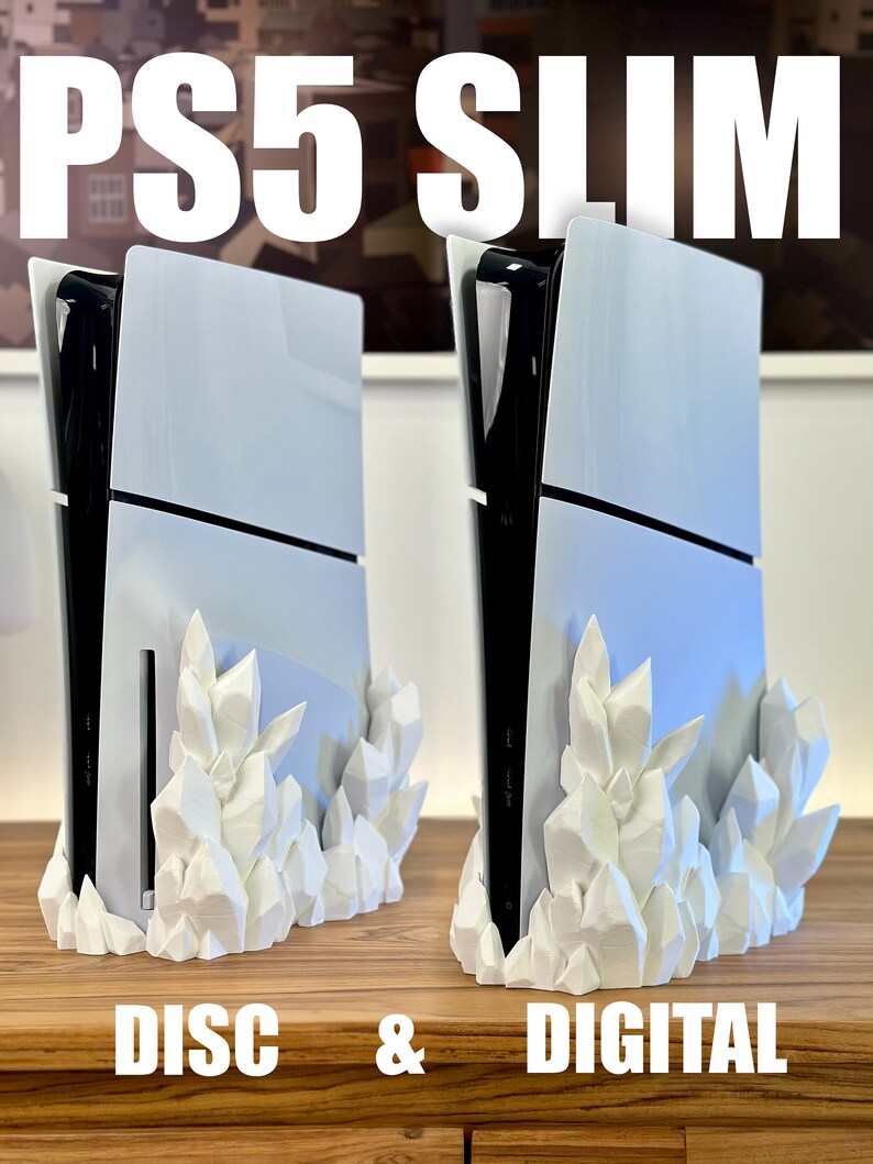 May include: Two white PS5 Slim consoles, one with a disc drive and one digital, are displayed on a wooden surface. Both consoles are on a white crystal-shaped stand.