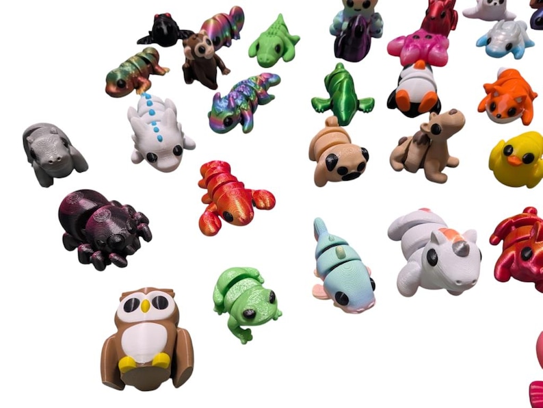 Peut inclure: Une collection de petites figurines d'animaux color&eacute;es, dont une araign&eacute;e, un hibou, une grenouille et un homard. Les figurines sont de diff&eacute;rentes couleurs, comme le marron, le vert et le rouge. La collection comprend une vari&eacute;t&eacute; de cr&eacute;atures.