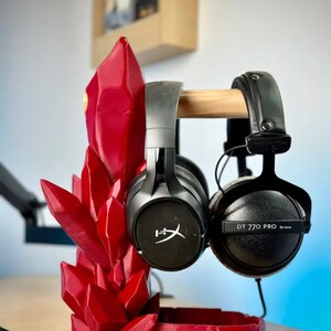 May include: A red crystal-shaped headphone stand with two pairs of headphones. One pair is black with the text "DT 770 PRO" and the other pair is black with a white logo.