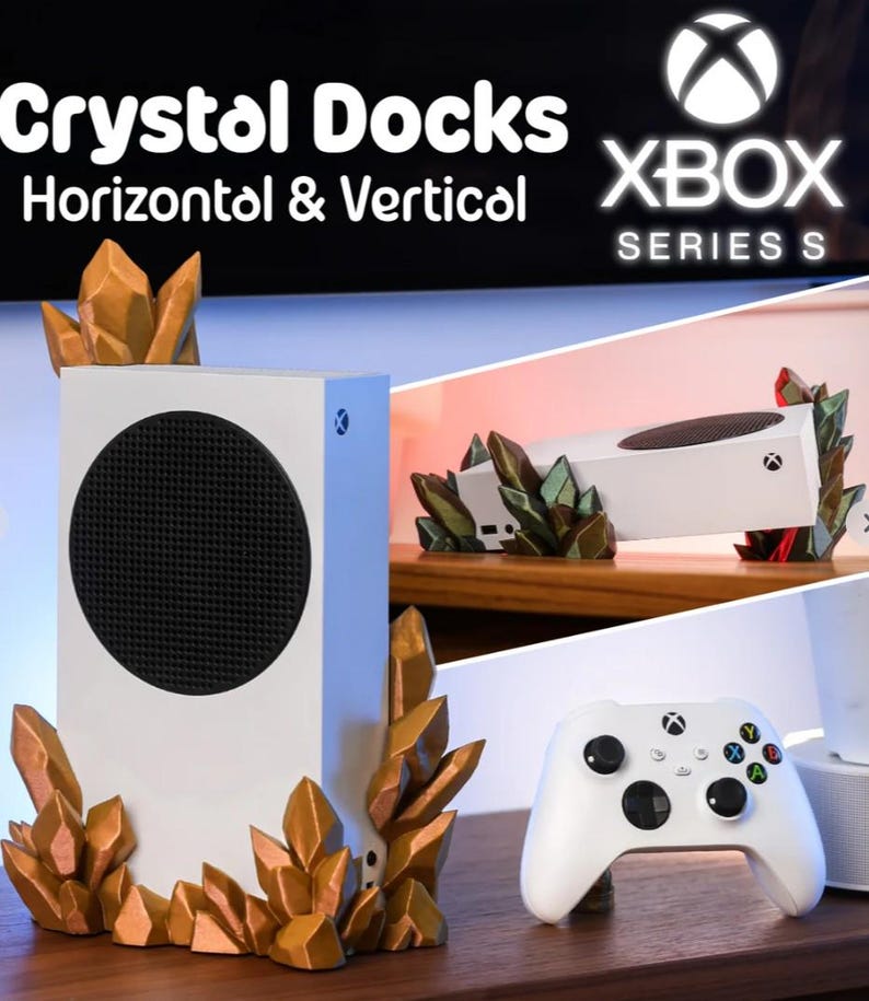 May include: White Xbox Series S console with a black circular vent and a matching white controller. The console is displayed with decorative crystal-shaped accents in shades of gold and green. The text "Crystal Docks Horizontal & Vertical" is visible.