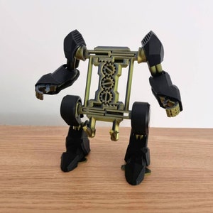 May include: A black and gold 3D printed robot with articulated arms and legs. The robot has a gear-like design on its torso.