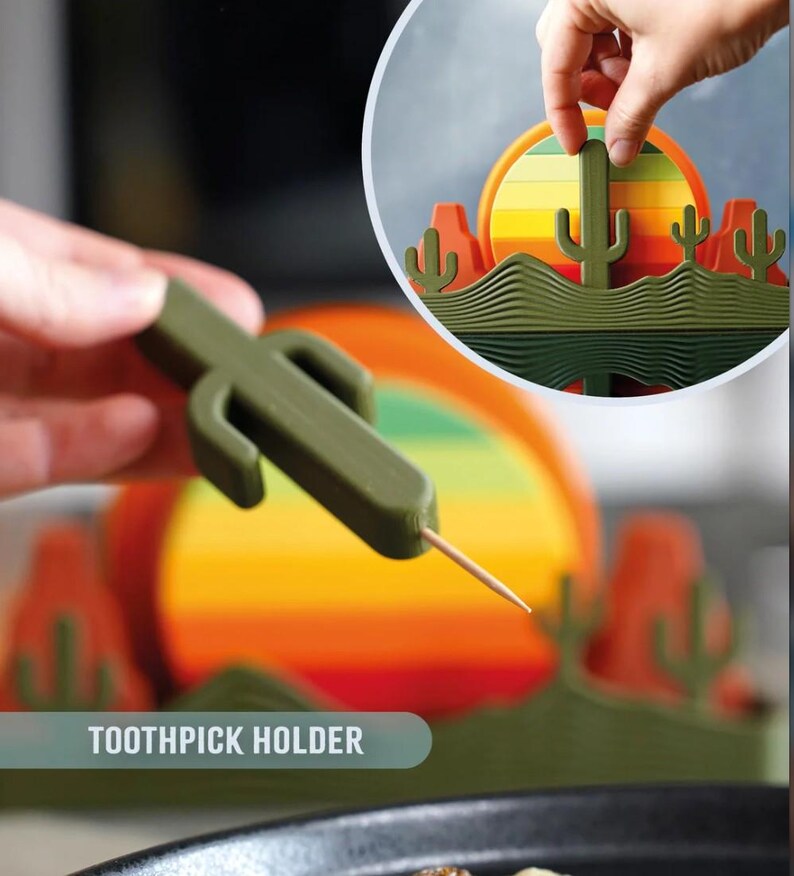 May include: A green cactus-shaped toothpick holder with a toothpick inserted. The image shows a desert-themed design with a sunset and cacti. The text "TOOTHPICK HOLDER" is visible.