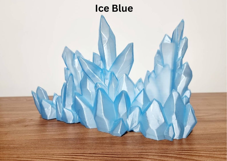 Puede incluir: Un c&uacute;mulo de cristales de color azul hielo, que se asemeja a una cordillera congelada, es una escultura de mesa decorativa.