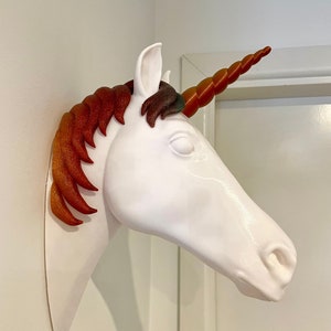 May include: White unicorn head wall mount with a red and orange mane and a spiral horn.