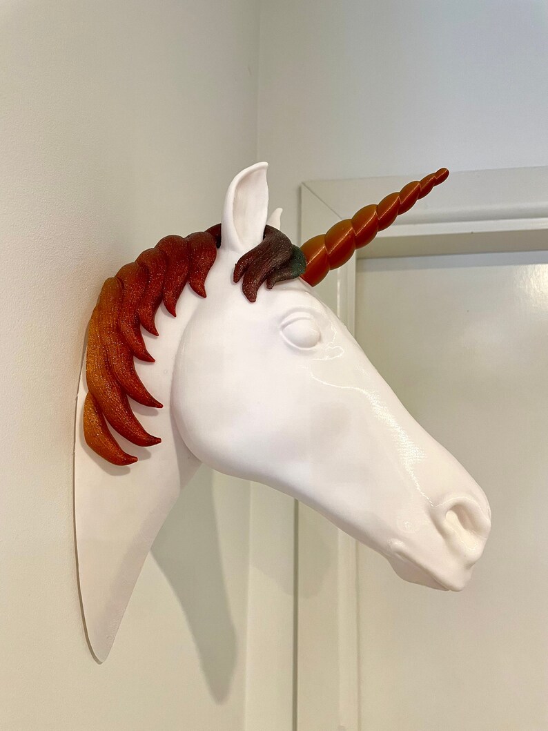 May include: White unicorn head wall mount with a red and orange mane and a spiral horn.