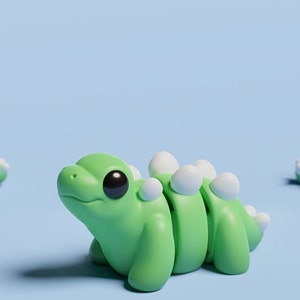 May include: Three green and white segmented dinosaur toys on a light blue background. The dinosaurs have large black eyes and white spines.