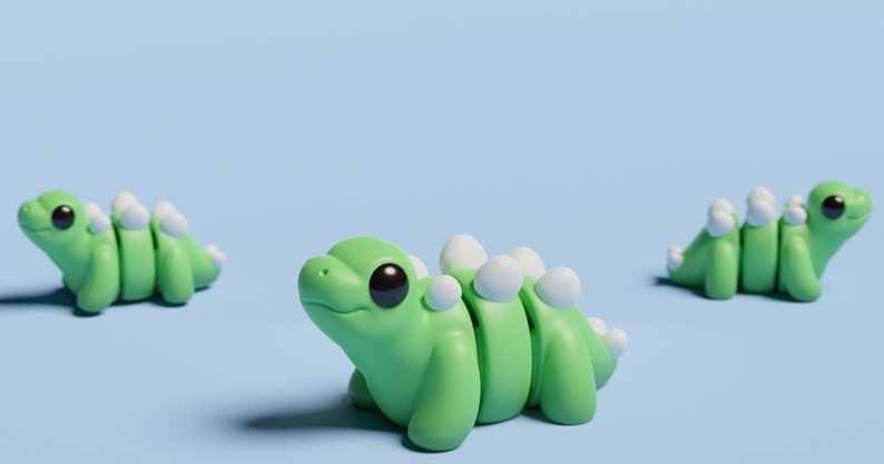 May include: Three green and white segmented dinosaur toys on a light blue background. The dinosaurs have large black eyes and white spines.