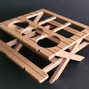 May include: A light brown wooden folding picnic table with three cup holders. The table is made of wood and has a simple design.