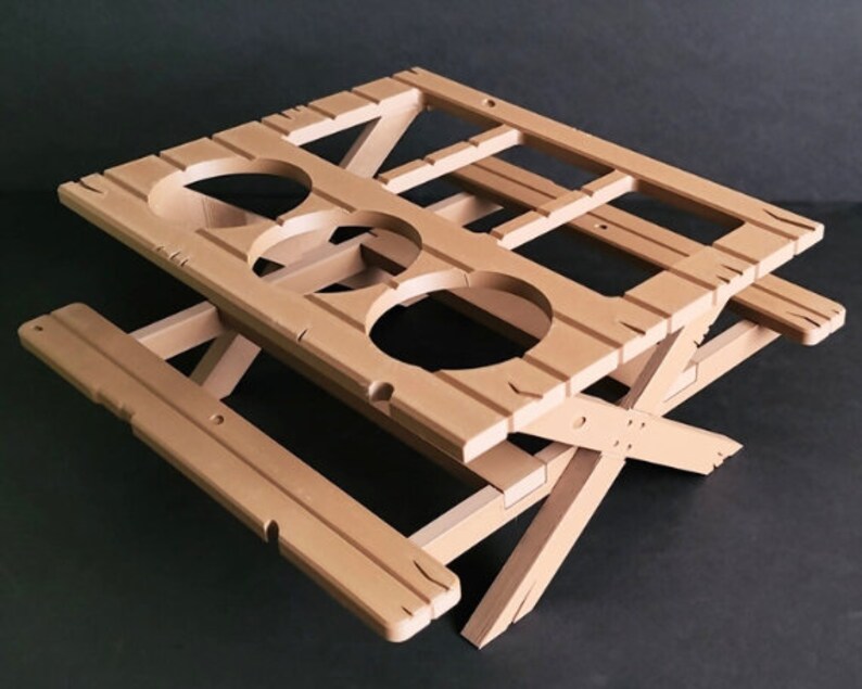 May include: A light brown wooden folding picnic table with three cup holders. The table is made of wood and has a simple design.