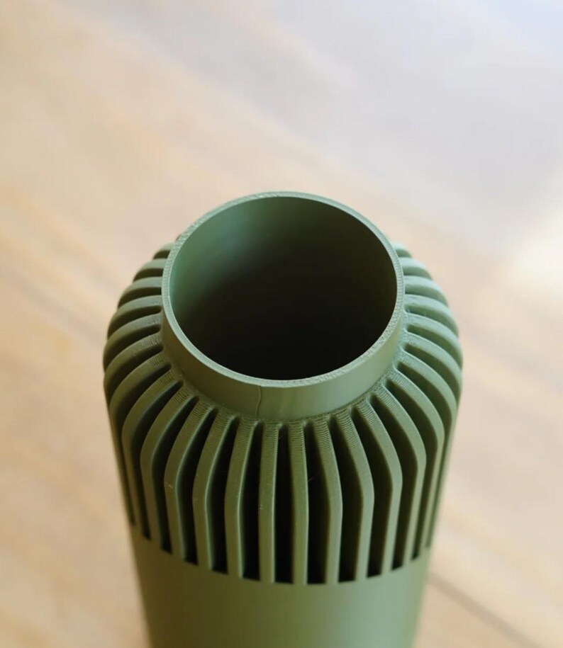 May include: A set of three ceramic mugs with a speckled, matte finish. The mugs are in shades of cream, light gray, and dark gray. Each mug has a simple, minimalist design and a rounded handle.