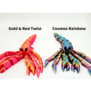 Puede incluir: Dos figuritas de escorpi&oacute;n impresas en 3D. Una es de color rosa brillante y naranja con el texto "Gold & Red Twist". La otra es un escorpi&oacute;n iridiscente multicolor con el texto "Cosmos Rainbow".