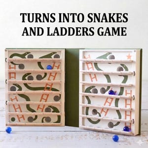 May include: A wooden Snakes and Ladders game with a green and white design. The game board features snakes, ladders, and wooden pegs. The text "TURNS INTO SNAKES AND LADDERS GAME" is at the top. Blue marbles are scattered around the game.