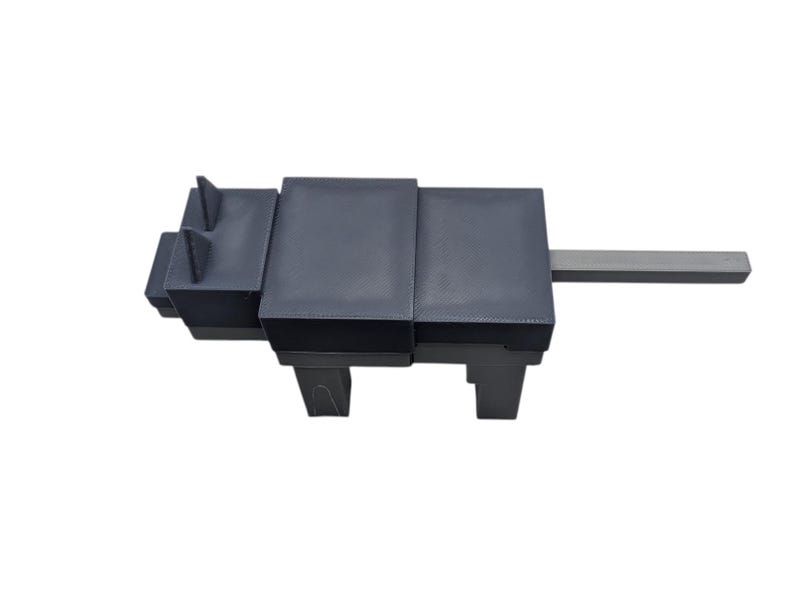 May include: A dark grey, geometric sculpture resembling an animal, possibly a dog or wolf. Constructed from rectangular blocks, it has a long, rectangular tail. The design is minimalist and contemporary, suitable for modern interiors. The sculpture is in the shape of a dog.