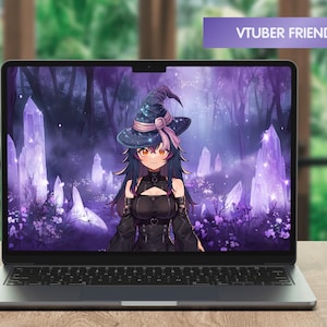 May include: A laptop computer displaying a purple and blue fantasy background featuring a witch with long black hair wearing a black dress and a witch's hat. The background includes glowing purple crystals and trees. The text "VTUBER FRIENDLY!" is displayed in a purple banner at the top of the screen.