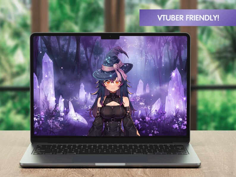 May include: A laptop computer displaying a purple and blue fantasy background featuring a witch with long black hair wearing a black dress and a witch's hat. The background includes glowing purple crystals and trees. The text "VTUBER FRIENDLY!" is displayed in a purple banner at the top of the screen.