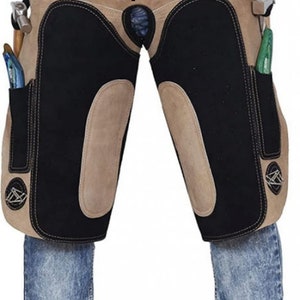 Könnte beinhalten: Eine braune Lederchaps mit schwarzen Lederpaneelen und mehreren Taschen. Die Chaps haben ein Pferdesilhouetten-Design auf der Vorderseite.