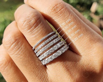 May include: Five silver-toned eternity bands featuring clear stones, stacked together. The bands are labeled with widths of 1.00 mm, 1.50 mm, 2.00 mm, 2.50 mm, and 3.00 mm, indicating the varying thickness of each individual ring in the set.