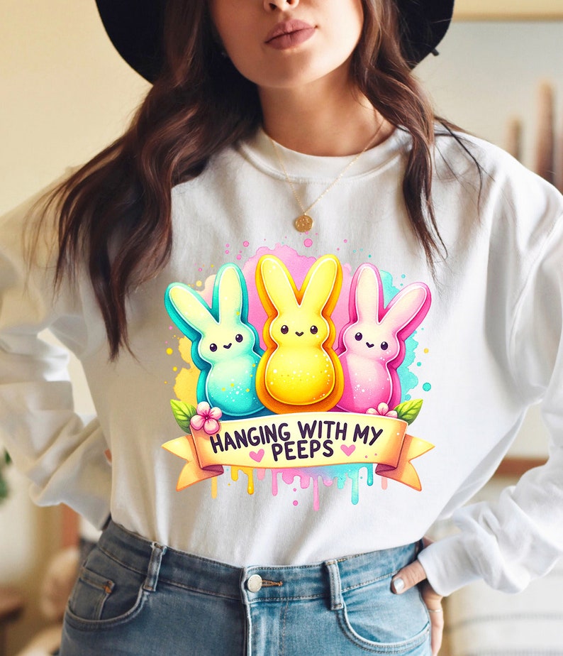 May include: White sweatshirt with a graphic of three colorful Peeps marshmallow candies and the text "Hanging with my Peeps".