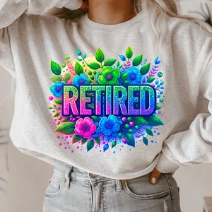 May include: A grey sweatshirt with a colourful floral design and the word "RETIRED" in rainbow glitter letters.