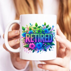 May include: White ceramic mug featuring a colourful floral design and the word "Retired" in rainbow glitter letters.