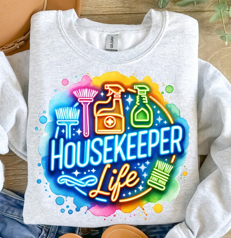 Może przedstawiać: Szara bluza z kolorowym nadrukiem przedstawiającym środki czystości i napis "Housekeeper Life".