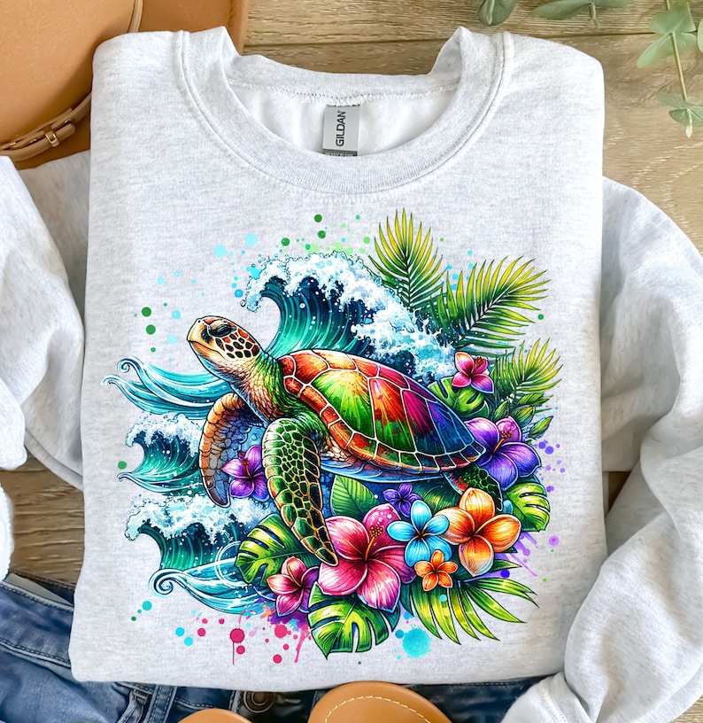 May include: A grey sweatshirt with a colorful graphic print of a sea turtle swimming in a wave with tropical flowers and leaves.