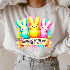 May include: A gray sweatshirt with a colorful graphic of three cartoon Peeps, a yellow Peep, a blue Peep, and a pink Peep. The graphic includes the text "Hanging with my Peeps".