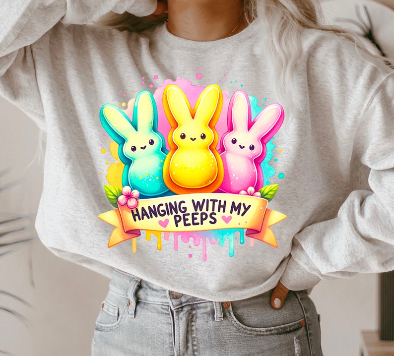 May include: A gray sweatshirt with a colorful graphic of three cartoon Peeps, a yellow Peep, a blue Peep, and a pink Peep. The graphic includes the text "Hanging with my Peeps".