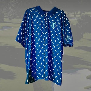 May include: A blue golf shirt with a white golfer pattern and a green logo on the right sleeve. The logo says "FORE!"