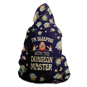 May include: A blue hooded blanket with a dice pattern and the text "I'm Sleeping With The Dungeon Master".