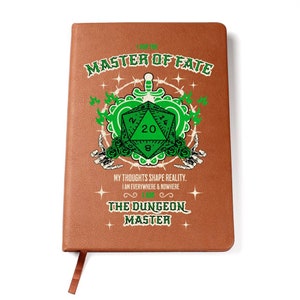 May include: A brown leather-bound journal with a green and white illustration of a twenty-sided die, a heart, and skeletal hands. The text "I AM THE MASTER OF FATE" is at the top of the journal. The text "MY THOUGHTS SHAPE REALITY. I AM EVERYWHERE & NOWHERE I AM THE DUNGEON MASTER" is at the bottom of the journal.