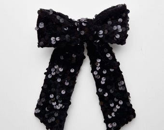 Fermaglio per capelli con fiocco in velluto e paillettes nere, accessorio vistoso per feste.