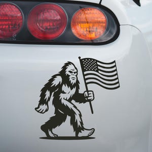 Bigfoot with American Flag Vinyl Decal – Sasquatch Car Sticker in Multiple Colors & Sizes | Funny Bigfoot Truck Decal, Bumper Sticker