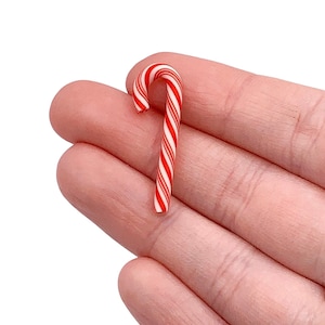 May include: A red and white candy cane with a traditional candy cane shape.
