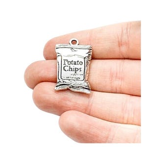 May include: Silver charm shaped like a bag of potato chips with the text "Potato Chips" on the front.