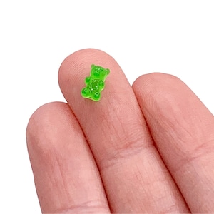 May include: A small green gummy bear shaped like a teddy bear.
