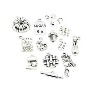 May include: A set of 14 silver charm pendants with baking and cooking themes. The charms include a cupcake, a cookbook, a rolling pin, a whisk, a pie, a cookie cutter, a measuring cup, a mixer, a sugar bag, a cookie, and a cake pan.