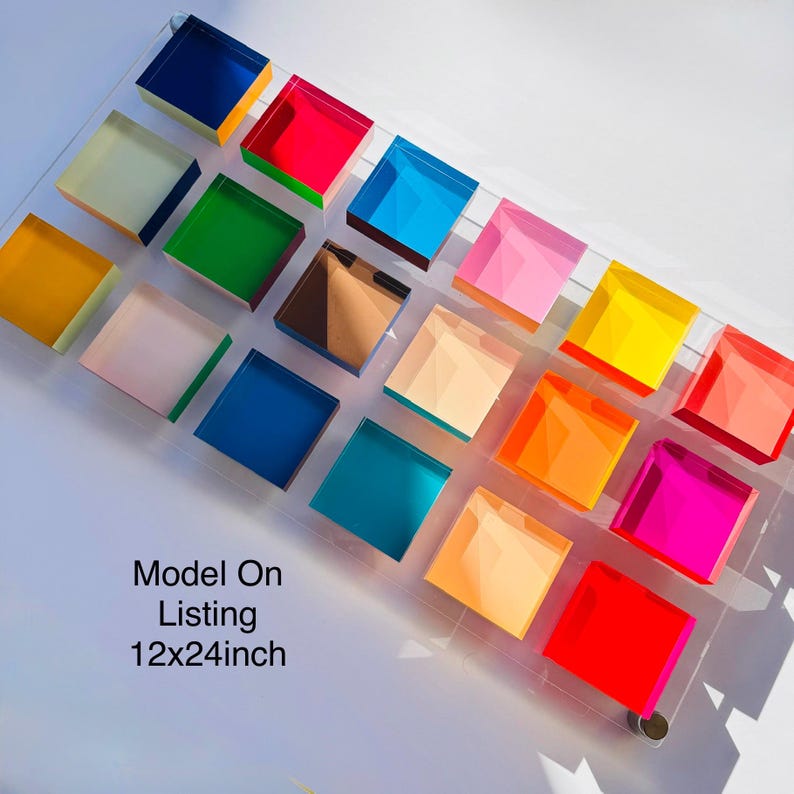 May include: A clear acrylic display featuring 20 colourful square blocks in shades of blue, green, pink, orange, and yellow. The blocks are arranged on a rectangular base, measuring approximately 30x61 cm. The text "Model On Listing" is visible.