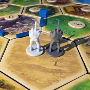 Pieza de repuesto divertida del ladrón de Catan con el dedo medio