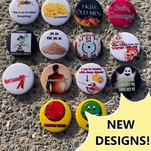 May include: A collection of fourteen circular pin-back buttons featuring various graphic designs, including illustrations of a wasp, scrambled eggs, a ghost, and text phrases such as I KISS OLD MEN, Brain Damaged, and CUBAN MISSILE CRISIS.