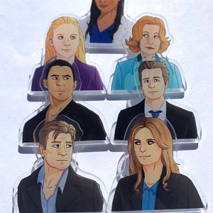 May include: Set of seven illustrated character portraits, each with a different hairstyle and facial expression. The characters are depicted in a cartoon style with a variety of skin tones and hair colours. The portraits are printed on clear acrylic.