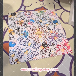 May include: White fabric with a repeating pattern of stylized winged creatures in black outline, with colorful accents. The design includes various cartoon characters and the text "omomoshop.etsy.com" in the bottom corner. The overall theme is whimsical and playful.
