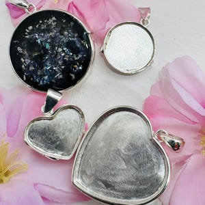 Peut inclure: Trois blancs de pendentif en argent pour la fabrication de bijoux. L'un est un blanc rond, et les deux autres sont en forme de cœur.